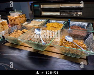 Frühstücksbüfett mit einer Auswahl an Müsli, Müsli, Müsli und Hafer in klaren Glasschalen. Kekse und Cracker gibt es auch Stockfoto