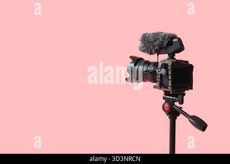 Professionelle Kamera auf Stativ vor rosa Hintergrund, Nahaufnahme Stockfoto