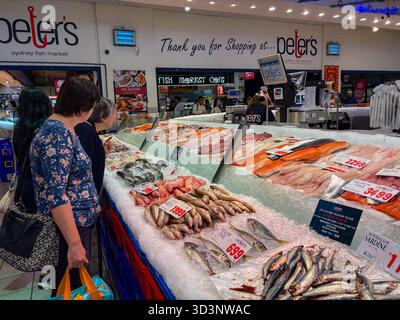 Sydney Fish Market, Australien. Die Gäste stöbern bei Peter's nach frischen Meeresfrüchten, darunter verschiedene Fischsorten wie Lachs und Sardinen, die auf Eis serviert werden Stockfoto