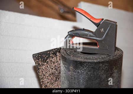 Bauhefter auf gewalztem Abdichtungsmaterial für Gebäudesanierungsarbeiten Stockfoto