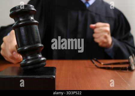 Nahaufnahme Szene im Gerichtssaal, die den Richter zeigt, wie er einen hölzernen Hammer auf den Block schlägt, Symbol für Recht, Autorität, Gerichtsentscheidung Stockfoto