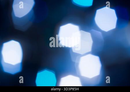 Foto Weißes und türkisfarbenes achteckiges Bokeh auf schwarzem Hintergrund – abstrakter geometrischer Feiertagshintergrund, Vorderansicht. Stockfoto