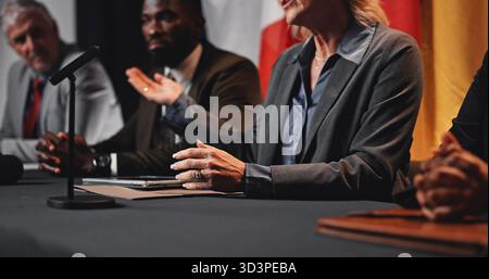 Hände, Podiumsdiskussionen und Flaggen auf internationalen Konferenzen für Geopolitik, Präsentation oder Ankündigung. Person, Sprecher und Botschafter in der Gruppe Stockfoto