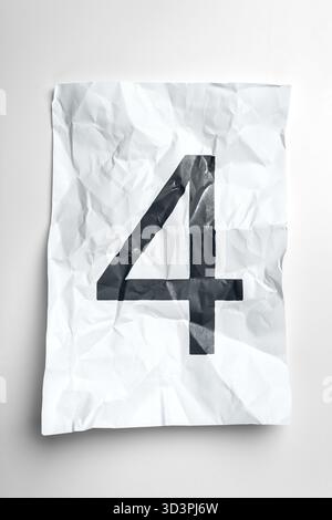 Zerknittertes Papier mit der Zahl vier deutlich sichtbar auf einer Ebenen Oberfläche Stockfoto