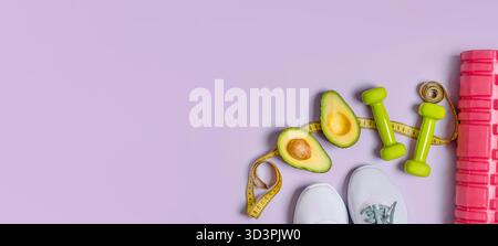Sportliche Fitness-Flat-Lay mit Sneakern, Kurzhanteln, Avocado auf einem lila isolierten Hintergrund Stockfoto