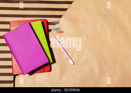 Farbenfrohe Notizbücher und Schreibwaren sind auf einer eleganten Arbeitsfläche angeordnet Stockfoto