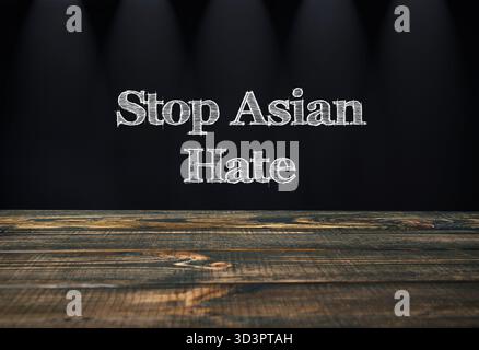 Stop Asian Hass ist schwarz auf hölzernem Hintergrund geschrieben. Das Bild vermittelt eine starke Botschaft gegen Hass und Diskriminierung gegenüber asiatischen Menschen Stockfoto