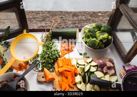 Eine lebhafte Auswahl an frisch gehackten Karotten, Zucchini und Brokkoli auf einem rustikalen Holztisch, die einen gesunden, biologischen Lebensstil und eine gesunde Mischung aus Stockfoto