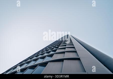 Ein beeindruckender Flachwinkelblick auf einen modernen Wolkenkratzer, Teil des Geschäftsviertels Cinco Torres in Madrid, Spanien. Die schlanken Linien und das Glas reflektieren die Klarheit Stockfoto