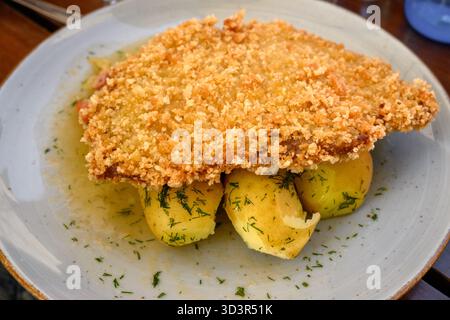 Gebratenes Schweinekotelett in Brotkrumen serviert mit Kartoffeln Stockfoto