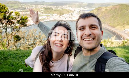 Ein fröhliches Selfie von Miradouro da Lira auf Monte da Guia, mit atemberaubendem Blick auf die Bucht und Praia do Porto PIM in Horta, Faial Island Stockfoto
