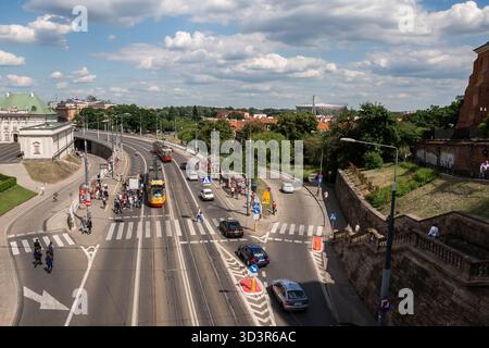 Warschau, Polen - 25. Juni 2015 - geschäftige Stadtstraße mit Straßenbahn und Fußgängern an einem bewölkten Tag. Stockfoto