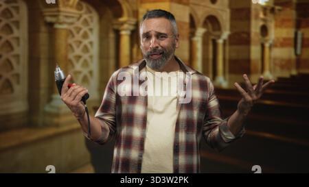 Mann mit Bohrer und Gesten mit Händen im Kirchenbau, Zimmermann bei der Arbeit; Glaubensreparatur-Verwirrung. Stockfoto