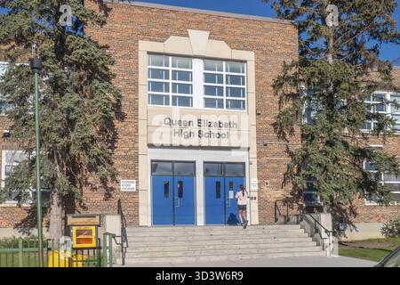 Calgary, Alberta, Kanada. Juni 2025. Queen Elizabeth High School steht mit klassischer Backsteinarchitektur, blauen Doppeltüren und großen Fenstern hin Stockfoto