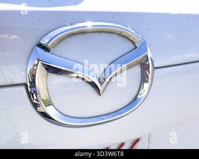 Calgary, Alberta, Kanada. Juni 2025. Ein glänzendes Mazda-Emblem auf der Oberfläche eines Fahrzeugs symbolisiert die Feinmechanik und das Engagement für das Fahrzeug Stockfoto