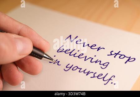 Schreiben Sie mit der Hand, und glauben Sie nie an sich selbst. Stockfoto