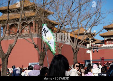 Der Reiseleiter hebt eine kleine Flagge über die Menschenmenge vor der Verbotenen Stadt in Peking Stockfoto