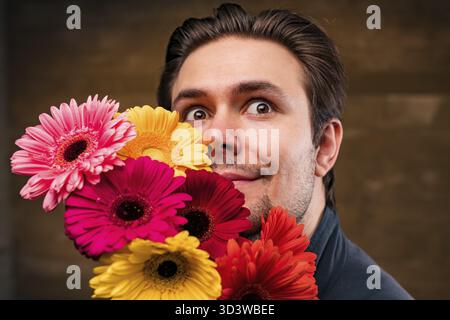 Junger, gutaussehender Mann mit Blumenporträt Stockfoto