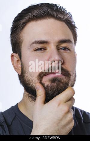Junger, nachdenklicher Mann mit Bartporträt auf weißem Hintergrund Stockfoto