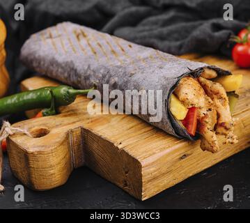 Essen, schwarzer Lavash mit Huhn auf schwarzem Brett Stockfoto