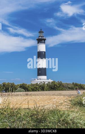 Der Leuchtturm von Chassiron mit schwarz-weißen Streifen am blauen Himmel auf der Insel Oleron in Frankreich Stockfoto