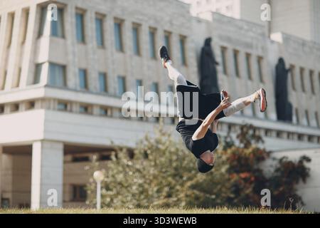 Junger sportlicher Kerl, der Parkour an der Stadtstraße macht Stockfoto