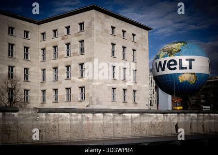 Die Welt, Finanzministerium DEU, Deutschland, Deutschland, Berlin, 03.11.2025 Heissluftballon der Zeitung die Welt beliebt bei Touristen und Reste der Berliner Mauer als Symbol für die ehemalige Teilung der Stadt sowie dem Bundesministerium der Finanzen nahe am Touristenschwerpunkt Charlie in Berlin Deutschland . Das Finanzministerium auch Detlev-Rohwedder-Haus genannt wurde in der Zeit des Nationalsozialismus 1935/1936 nach Plaenen des Architekten Ernst Sagebiel als Reichsluftfahrtministeriums errichtet en: Ein Heißluftballon der bei Touristen beliebten Zeitung die Welt Stockfoto