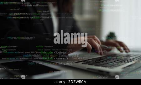 Ein fokussierter Programmierer verwendet einen Laptop, der in die Softwareentwicklung eingetaucht ist und durch Codezeilen hervorgehoben wird, die seinen kreativen Arbeitsbereich in einem beleuchten Stockfoto