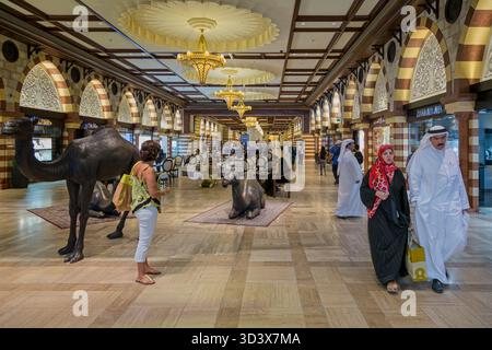 Erwachsene, männliche und weibliche emirate in traditionellen knöchellangen Bademänteln und Kopftüchern, die am 18. September 2013 in der Dubai Mall, Dubai, VAE, spazieren Stockfoto