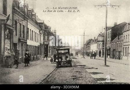 Dieses Foto von 1900 bis 1910 zeigt ein Auto in der Rue de Lille in La Madeleine. Das Bild zeigt die wechselnden Verkehrsmittel während des frühen 20. Jahrhunderts in dieser nordfranzösischen Stadt. Stockfoto