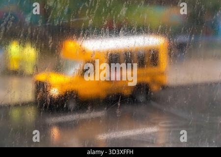 Schulbus vor der PS33 in Chelsea in New York, gesehen durch ein Regen und Wind spritzte Fenster am Donnerstag, den 30. Oktober 2025 während eines Regensturms. (© Richard B. Levine) Stockfoto