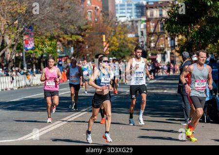 Die Läufer fahren am Sonntag, den 2. November 2025 beim TCS New York City Marathon durch Harlem in New York nahe der 22-km-Marke in der Nähe des Mount Morris Park. 50.000+ Teilnehmer liefen durch die fünf Bezirke. (© Richard B. Levine) Stockfoto