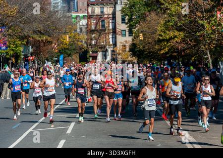 Die Läufer fahren am Sonntag, den 2. November 2025 beim TCS New York City Marathon durch Harlem in New York nahe der 22-km-Marke in der Nähe des Mount Morris Park. 50.000+ Teilnehmer liefen durch die fünf Bezirke. (© Richard B. Levine) Stockfoto