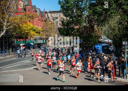 Die Läufer fahren am Sonntag, den 2. November 2025 beim TCS New York City Marathon durch Harlem in New York nahe der 22-km-Marke in der Nähe des Mount Morris Park. 50.000+ Teilnehmer liefen durch die fünf Bezirke. (© Richard B. Levine) Stockfoto