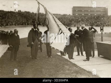 Bei den Olympischen Spielen 1928 in Amsterdam erhält Stadtrat Vos, amtierender Bürgermeister von Amsterdam, die Olympische Flagge von Graf Baillet Latour, Präsident des Internationalen Olympischen Komitees (IOC), als Symbol für den Übergang der Olympischen Spiele zur Austragungsstadt. Stockfoto