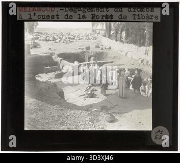 Ein weiteres Glasdiapositiv aus der Zeit um 1924-1932, das Arbeiter zeigt, die an der Reinigung der westlichen Dromos im Tempel von Montu beteiligt waren und die sorgfältige Restaurierung und Pflege der historischen Stätte unterstreicht. Stockfoto