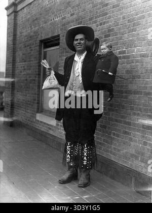 Dieses Foto von 1926 zeigt Jim Tarver aus Texas, der über 2 Meter groß stand und Major Mike hob, der nur 57 cm groß war. Dieses eindrucksvolle Bild erfasst einen Kontrast der physischen Größe. Stockfoto
