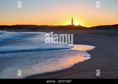 Cape Trafalgar, wunderschöner Sonnenuntergang mit Leuchtturm und sanften Wellen. Stockfoto
