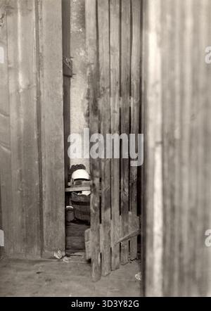 Der Eingang zu einem schlecht isolierten Dachboden in einem baufälligen Haus in Amsterdam, 1920. Dieses Foto zeigt die unzureichenden Wohnbedingungen, denen die Bewohner während der Zeit gegenüberstanden. Stockfoto