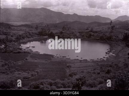 Ein Foto aus der Zeit um 1900, das den Kratersee nahe Baso in West Sumatra, Indonesien, zeigt, von der Straße nach Pajacombo aus gesehen, was die Infrastruktur aus der Kolonialzeit hervorhebt. Stockfoto