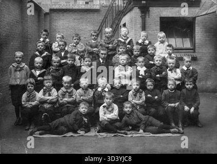 Ein Klassenfoto von einer Jungen-Schule in den Niederlanden, aufgenommen zwischen 1910 und 1920. Das Foto zeigt eine Gruppe von Schülern in ihrem Klassenzimmer und bietet einen Einblick in das Bildungsleben des frühen 20. Jahrhunderts in den Niederlanden. Stockfoto