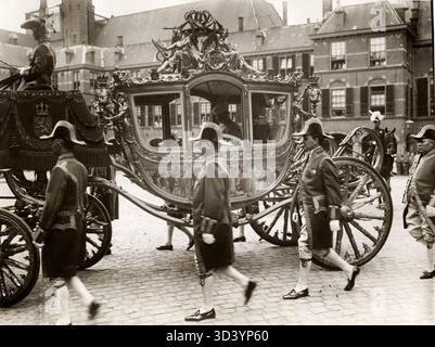 Am Prinsjesdag 1917 fährt Königin Wilhelmina in der goldenen Kutsche umgeben von Fußgängern zum Ridderzaal zur Eröffnung der Generalstaaten in den Haag, Niederlande. Stockfoto