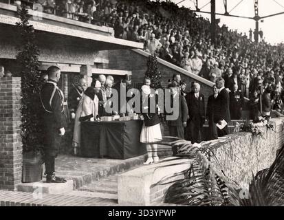 Während der Olympischen Spiele 1928 in Amsterdam vergibt Königin Wilhelmina die Goldmedaille für den 100-Meter-Rückschlag an Marie (ZUS) Braun. Ebenfalls anwesend ist Lambertus (BEP) van Klaveren, Goldmedaillengewinner im Federgewicht. Stockfoto