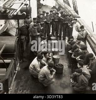 Auf dem Ausbildungsschiff "Pollux" in Amsterdam lernen Rekruten, Kartoffeln zu schälen und andere lebenswichtige Aufgaben an Bord eines Ausbildungsschiffs, 1918, auszuführen. Stockfoto