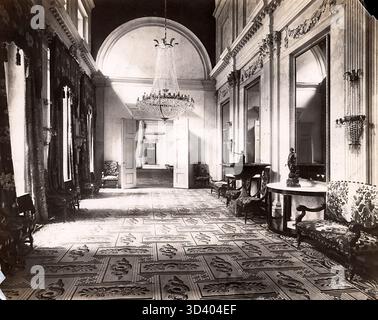 Ein Salon in der südlichen Galerie des Königlichen Palastes auf dem Dam-Platz in Amsterdam, fotografiert 1918. Der Raum verfügt über einen Kronleuchter und ein Sofa, die die elegante Inneneinrichtung des Palastes widerspiegeln. Stockfoto