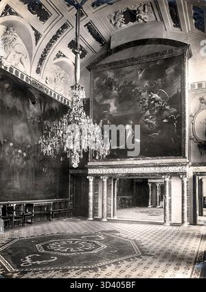 Die Moses-Halle im Königlichen Palast am Dam-Platz, Amsterdam, fotografiert 1918. Der Raum ist mit einem Kronleuchter und einem großen Gemälde geschmückt, das den künstlerischen und architektonischen Reichtum des Palastes verdeutlicht. Stockfoto