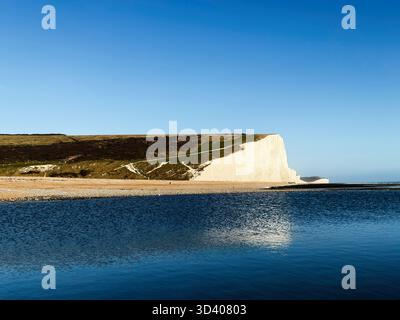 Eine ruhige Küstenlandschaft mit weißen Kreidefelsen, ruhigem blauem Meer und klarem Himmel. Stockfoto