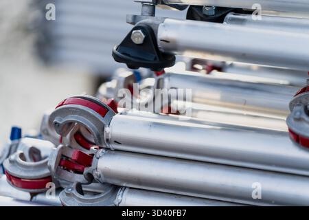 Stapel von metallischen Gerüstrohren mit Klemmen und Steckverbindern für Baustellenmaterial, Industrielogistik, modulare Rahmenkonstruktion Stockfoto