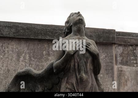 Nahaufnahme einer Engelsstatue mit verwitterter Oberfläche auf dem Friedhof Powązki. Stockfoto