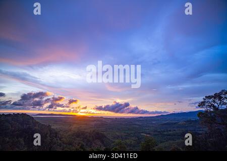 Aus der Vogelperspektive, wenn sich der Himmel zur Poesie wendet. Die verblasste Sonne schreibt Lichtverse über die Wolken, die den Abendhimmel in lebendige Poesie verwandeln Stockfoto